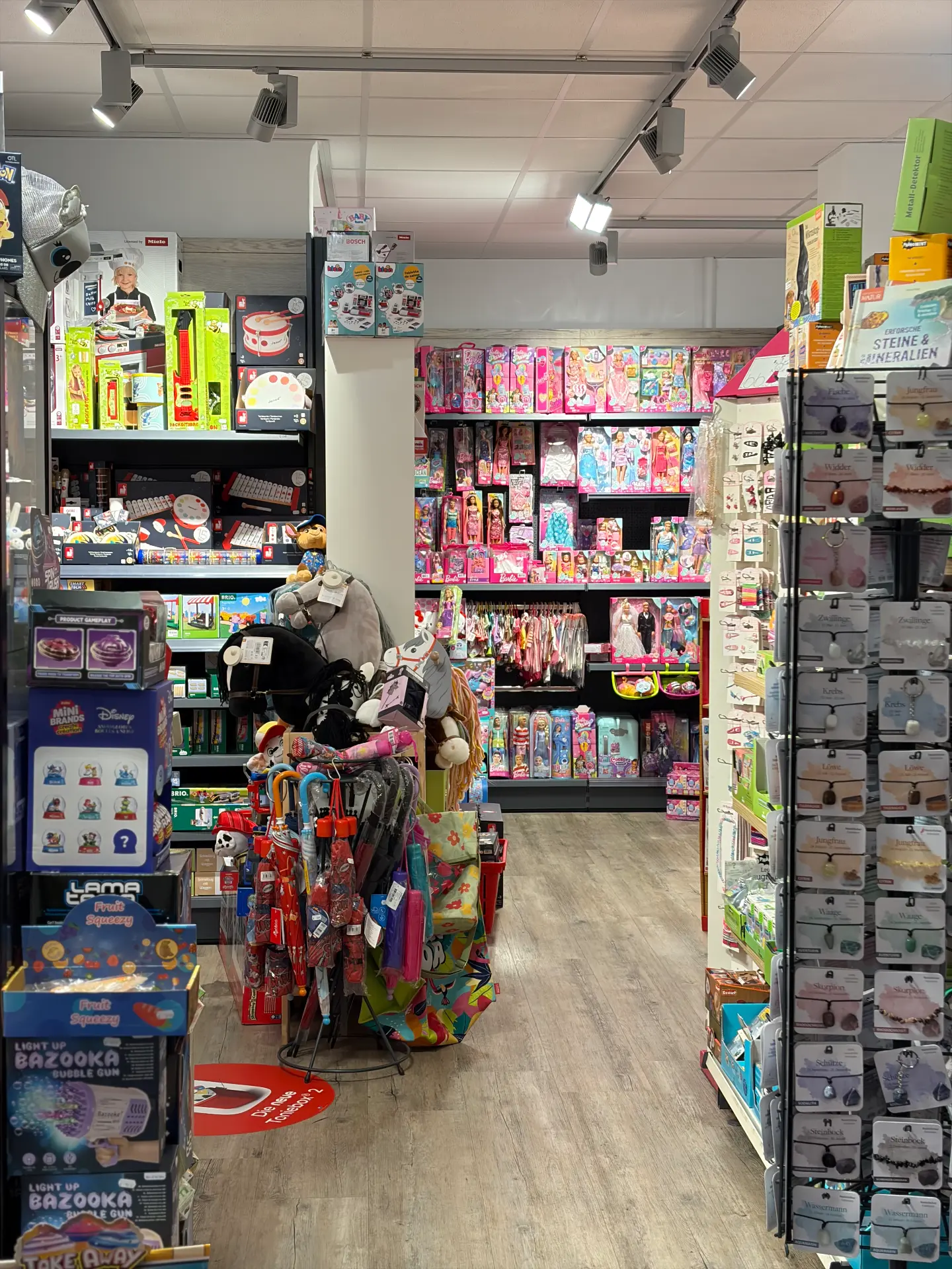 Ladeninnenraum mit Regalen voller Brettspiele, Kinder-Musikinstrumente, Puppen und Plüschtiere