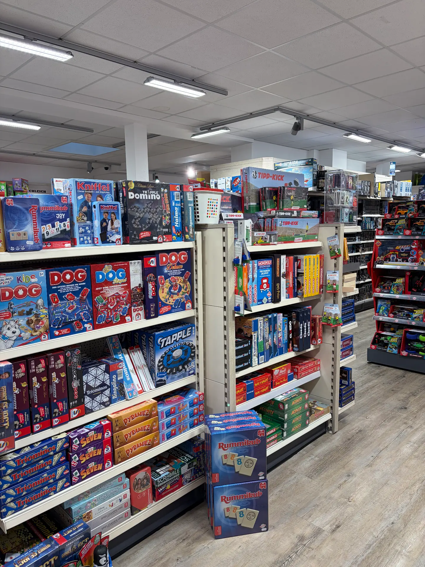 Regale mit Spieleklassikern wie Dog, Rummikub, Kniffel und Monopoly