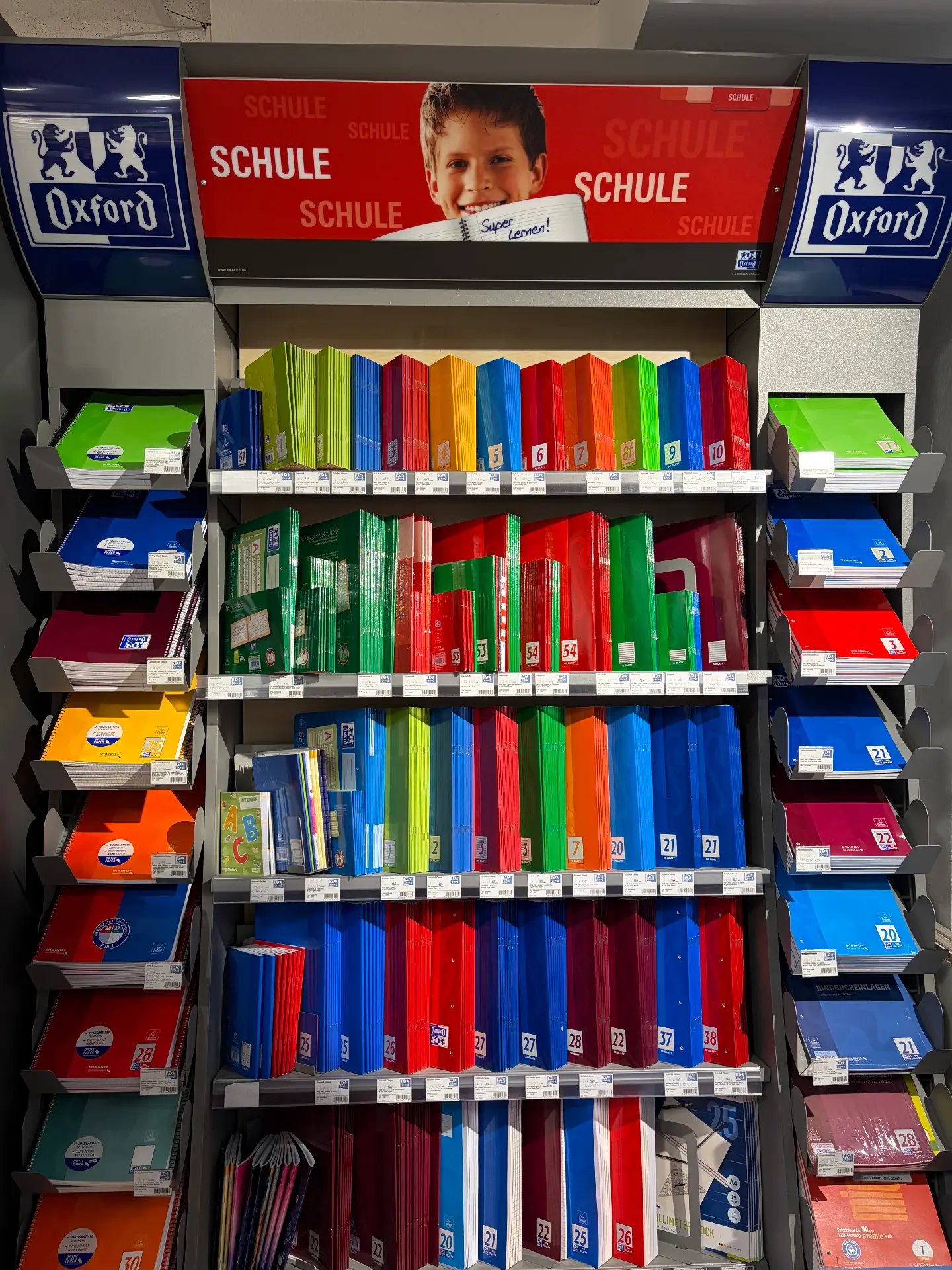 Blaues Oxford-Display mit Schulheften und Blöcken in vielen Farben