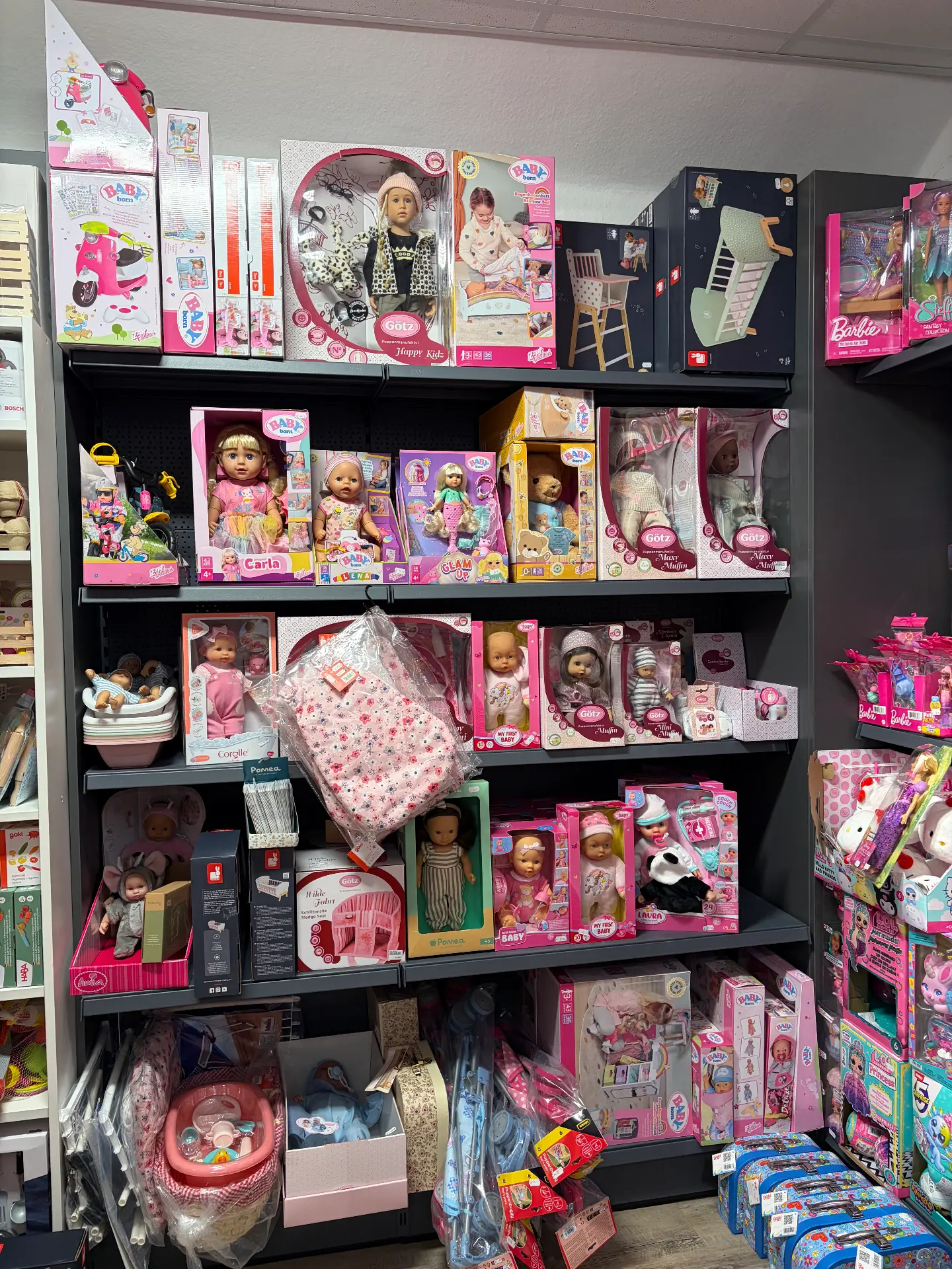 Regal mit Puppen und Zubehörsets von Baby Born, Götz und Barbie