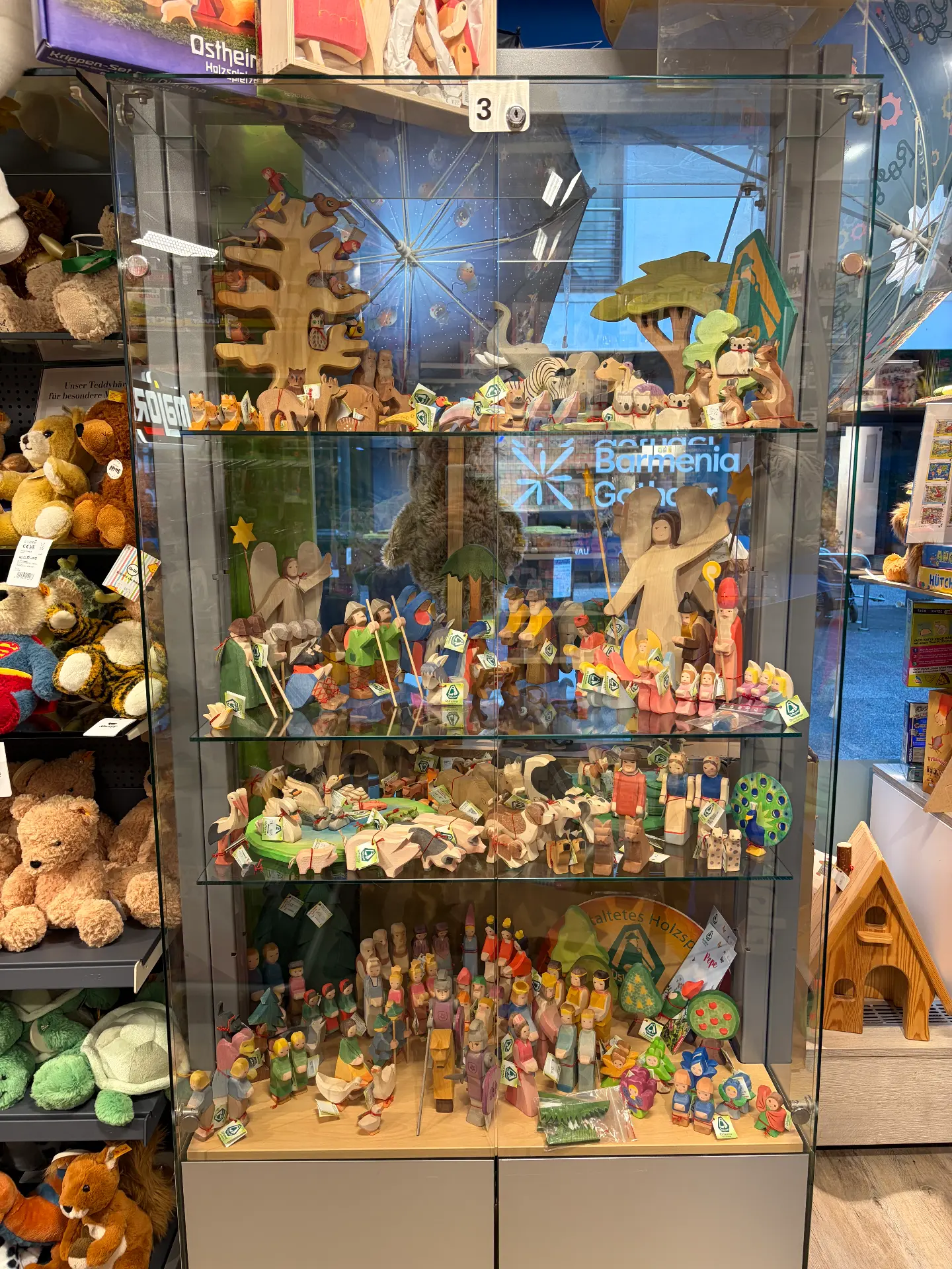 Beleuchtete Glasvitrine mit handgefertigten Ostheimer-Holzfiguren wie Tieren und Krippenszene