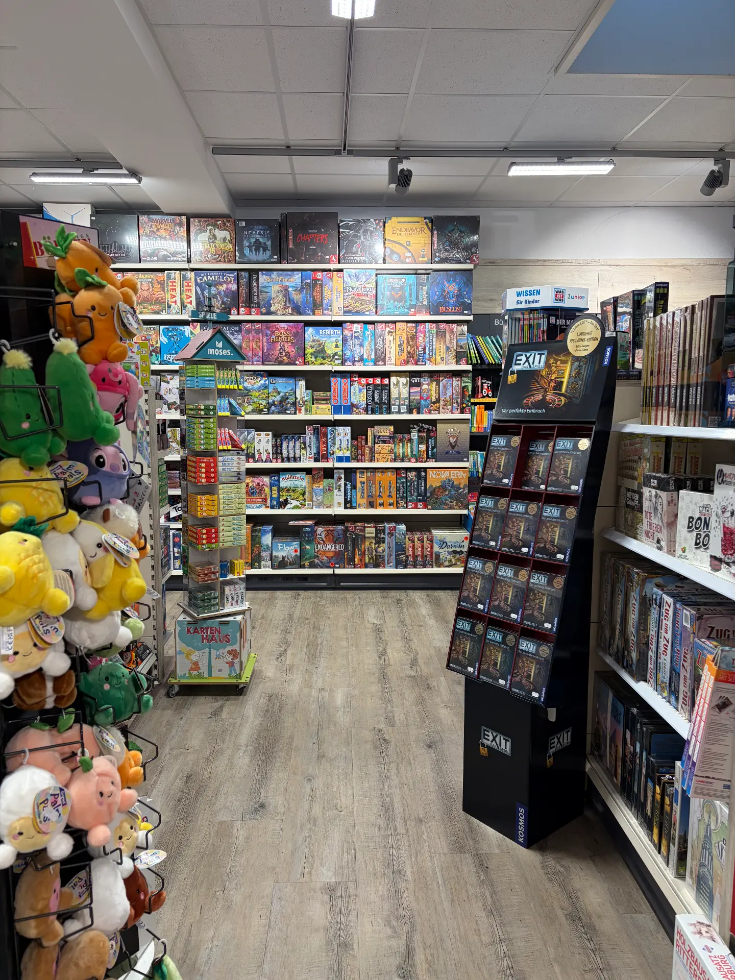 Spielecke mit einem Display für die EXIT-Spielereihe, dahinter Regale mit Brettspielen